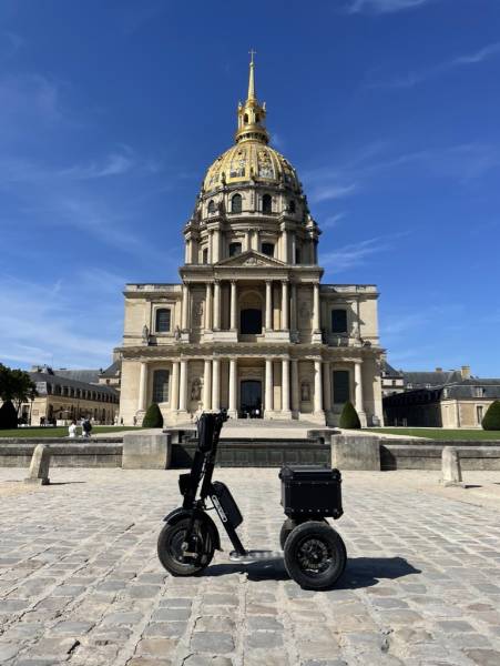 Triporteur électrique Cobrane trois roues devant les Invalides – vélo publicitaire mobile pour street marketing et animations commerciales dans les sites touristiques parisiens.